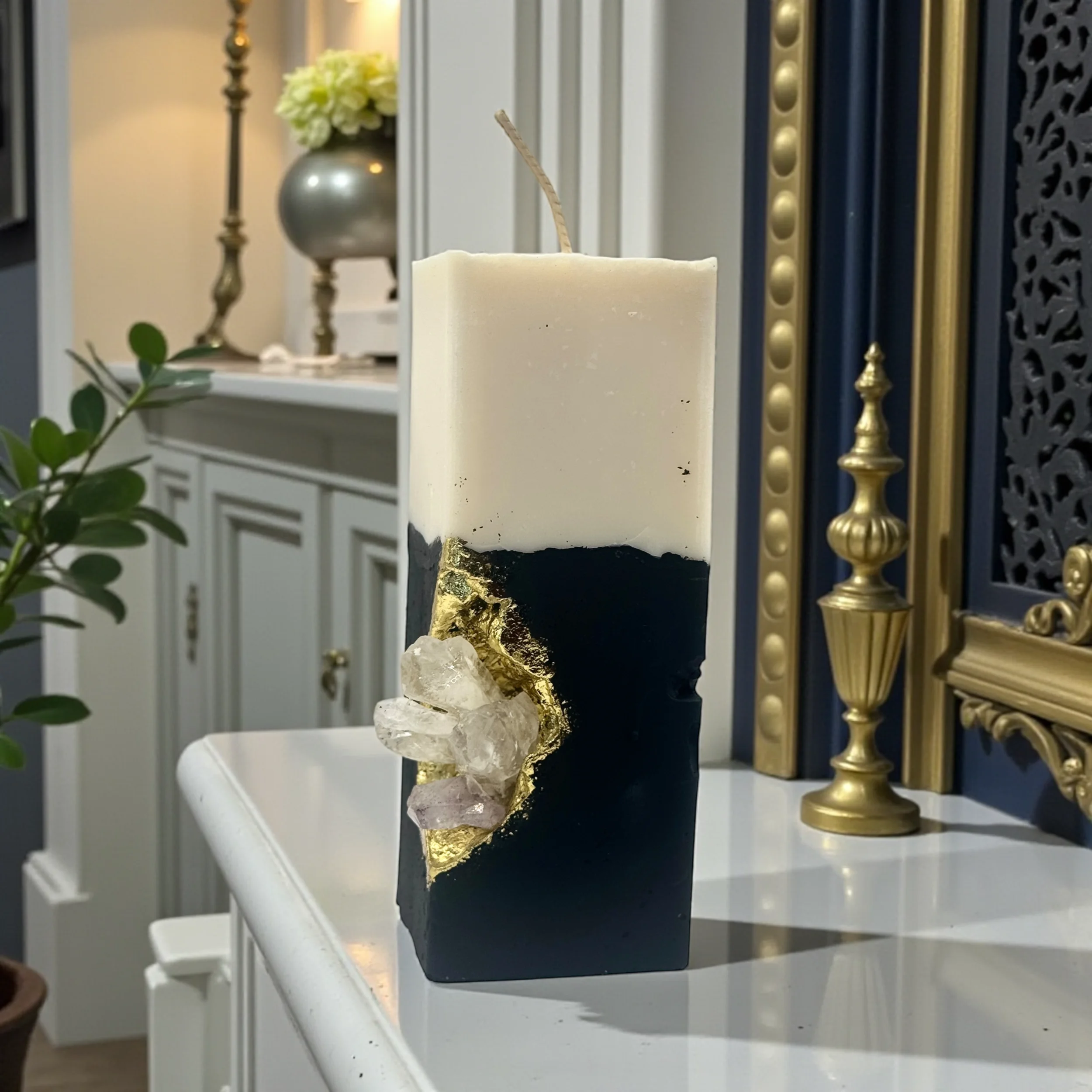 Luxury handmade crystal candle with natural gemstones, black sculpted base and gold accents, minimalist interior décor