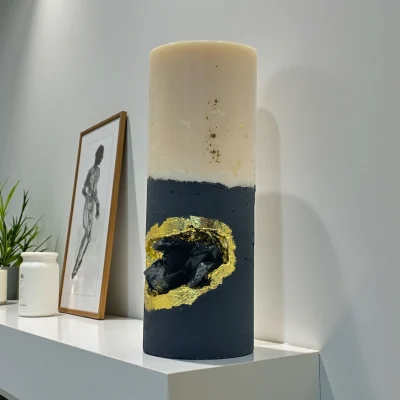 Midnight Ritual luxury handmade soy wax candle with black and ivory layers, gold leaf accents and a natural obsidian crystal, dark statement décor.