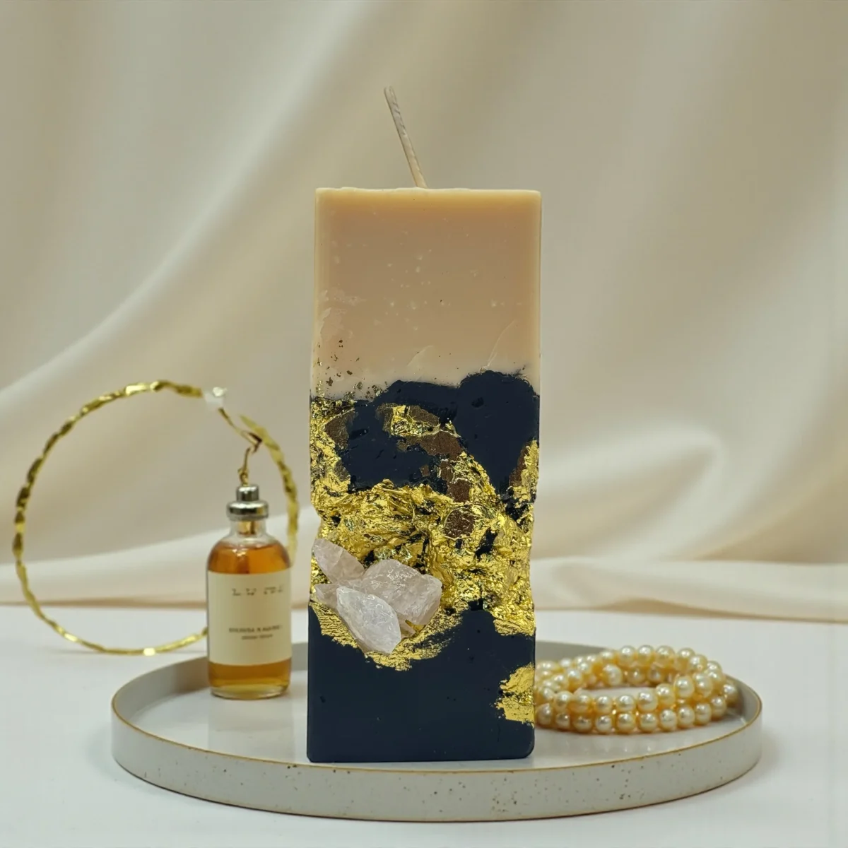 Smoky Seduction luxury handmade soy wax candle with black and ivory layers, gold leaf accents and a natural rose quartz crystal, elegant statement décor.