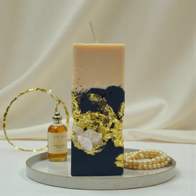 Smoky Seduction luxury handmade soy wax candle with black and ivory layers, gold leaf accents and a natural rose quartz crystal, elegant statement décor.