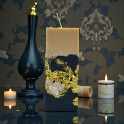 Smoky Seduction luxury handmade soy wax candle with black and ivory layers, gold leaf accents and a natural rose quartz crystal, elegant statement décor.